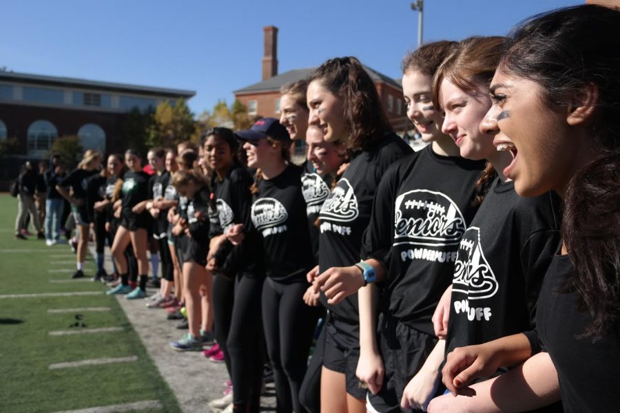 SWEET SIXTEEN– Members of the senior powderpuff team cheer on their teammates from the sidelines. The junior vs. senior powderpuff game is one several time-honored Spirit Week traditions
