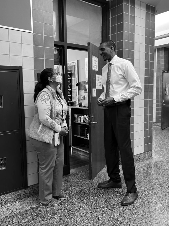 MORNING ROUNDS - Principal Sah Brown pauses on his daily hall walks to chat with a teacher before class one morning.