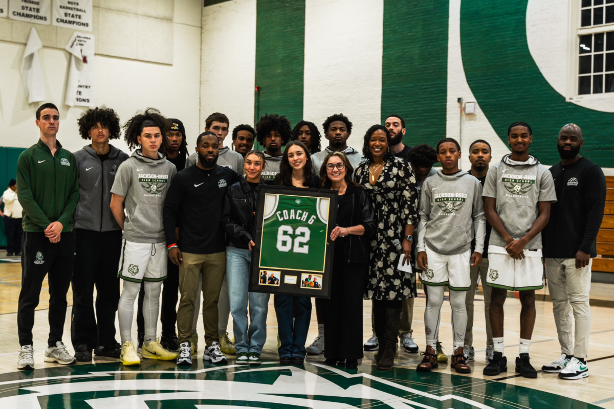 TIGER FAMILY: The varsity basketball team and the Anifantis family pose for a picture at center court pregame to celebrate Coach G night.